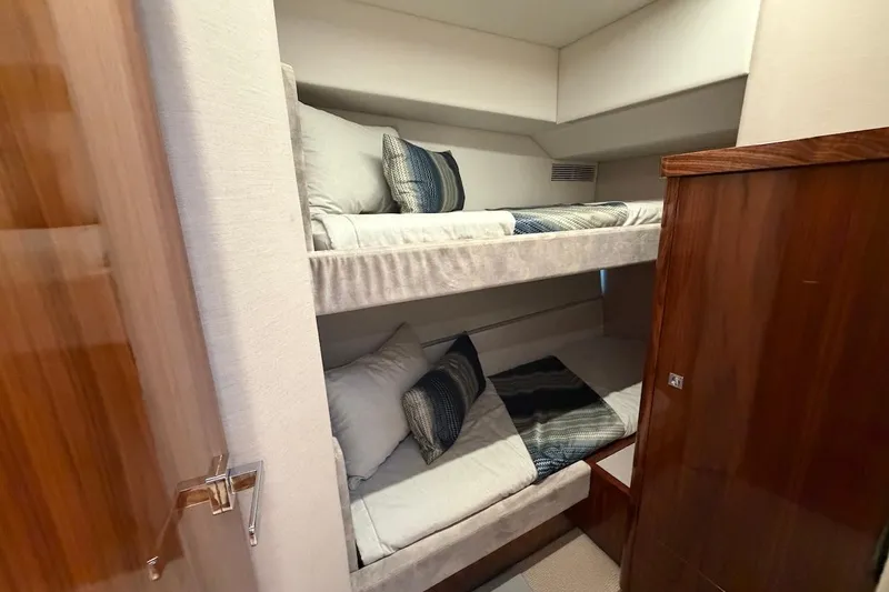  Yacht Photos Pics Bunk beds in 2021 Riviera 50 Sports Motor Yacht cabin, featuring modern design and cozy bedding.