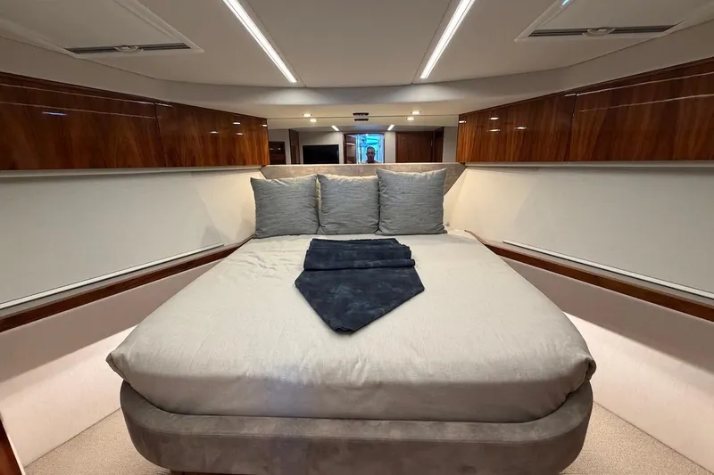  Yacht Photos Pics Luxurious bedroom interior of 2021 Riviera 50 Sports Motor Yacht with elegant wood finishes.
