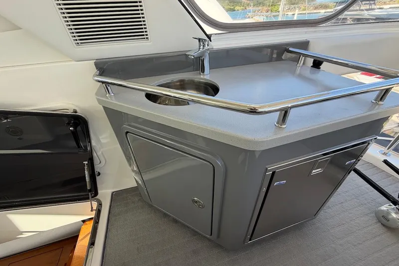  Yacht Photos Pics 2021 Riviera 50 Sports Motor Yacht interior with sleek kitchenette and stainless steel sink.