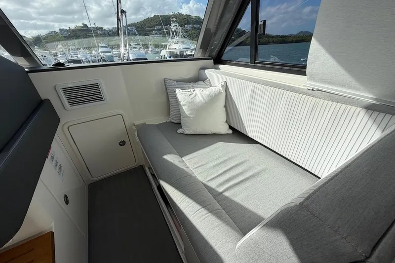  Yacht Photos Pics Interior seating area of 2021 Riviera 50 Sports Motor Yacht with cushions and window view.