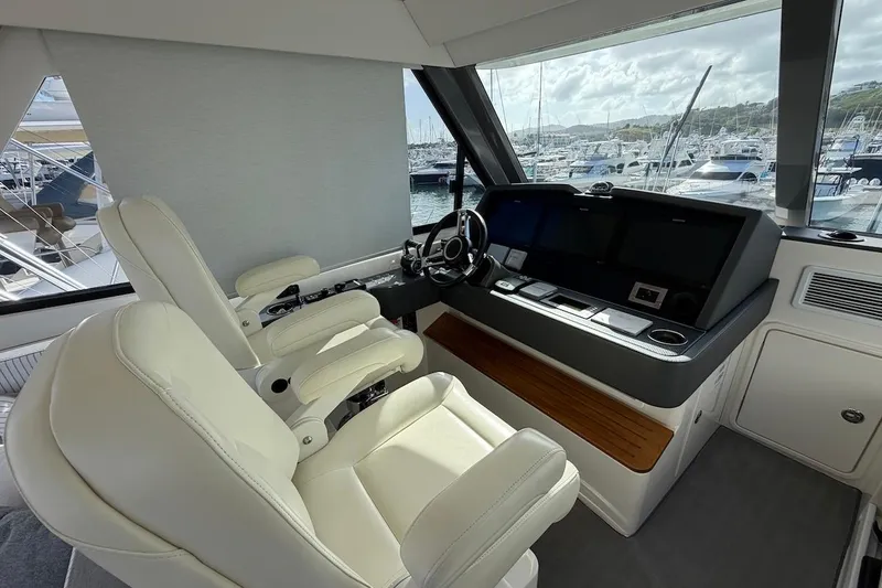  Yacht Photos Pics Interior helm of 2021 Riviera 50 Sports Motor Yacht with modern controls and seating.