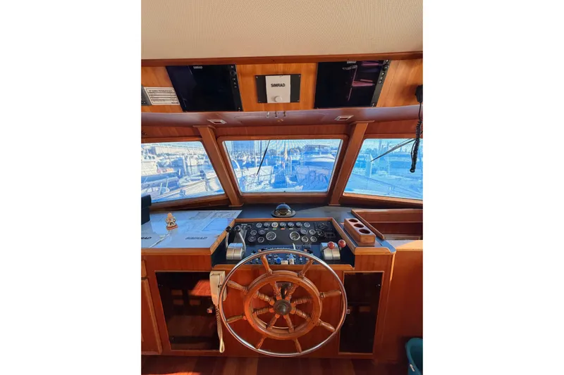 All The Way Yacht Photos Pics Helm of 1984 Hartman-Palmer 60 Flush Deck Motor Yacht with wooden steering wheel and navigation equipment.