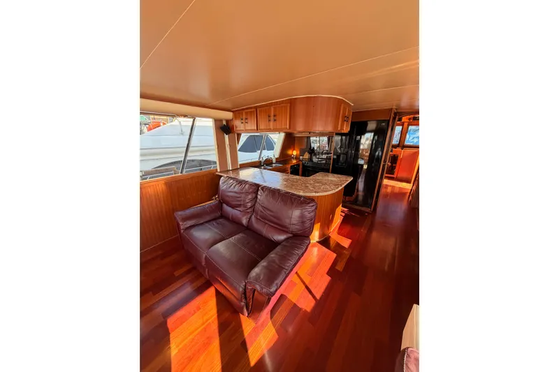 All The Way Yacht Photos Pics Interior of 1984 Hartman-Palmer 60 Flush Deck Motor Yacht with leather sofa and wooden cabinetry.