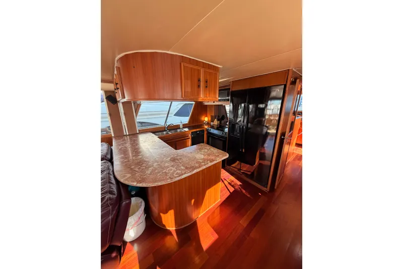 All The Way Yacht Photos Pics Interior of 1984 Hartman-Palmer 60 Flush Deck Motor Yacht with wood finishes and modern kitchen.