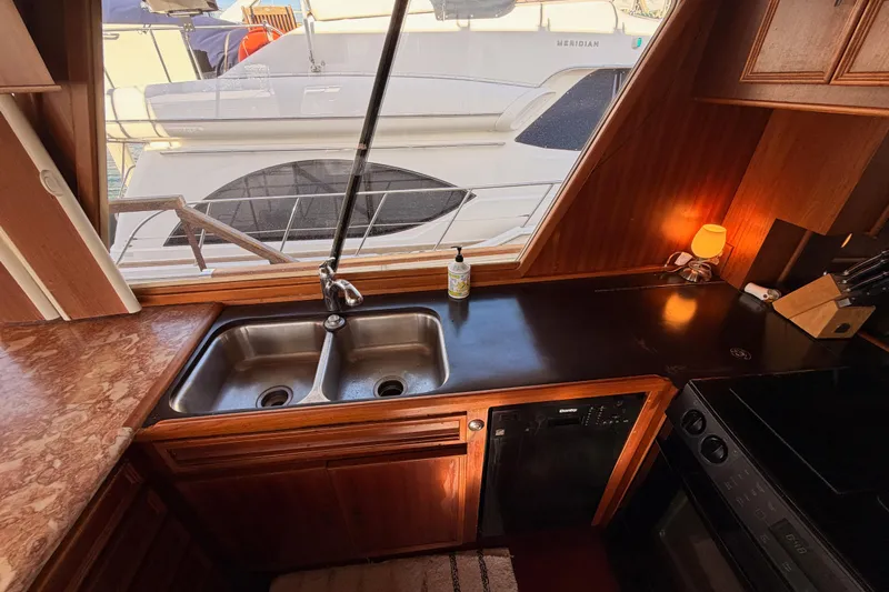 All The Way Yacht Photos Pics Interior of 1984 Hartman-Palmer yacht kitchen with sink, countertop, and window view.