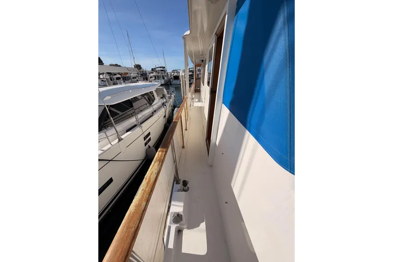 All The Way Yacht Photos Pics 1984 Hartman-Palmer 60 Flush Deck Motor Yacht docked, side view with blue canopy.