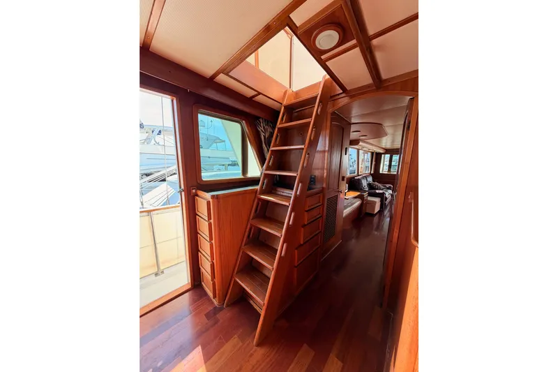 All The Way Yacht Photos Pics 1984 Hartman-Palmer 60 Flush Deck Motor Yacht interior with wooden ladder and cozy seating area.