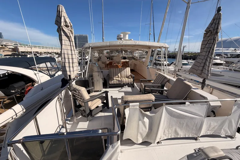 All The Way Yacht Photos Pics 1984 Hartman-Palmer 60 Flush Deck Motor Yacht with outdoor seating and umbrellas at marina.