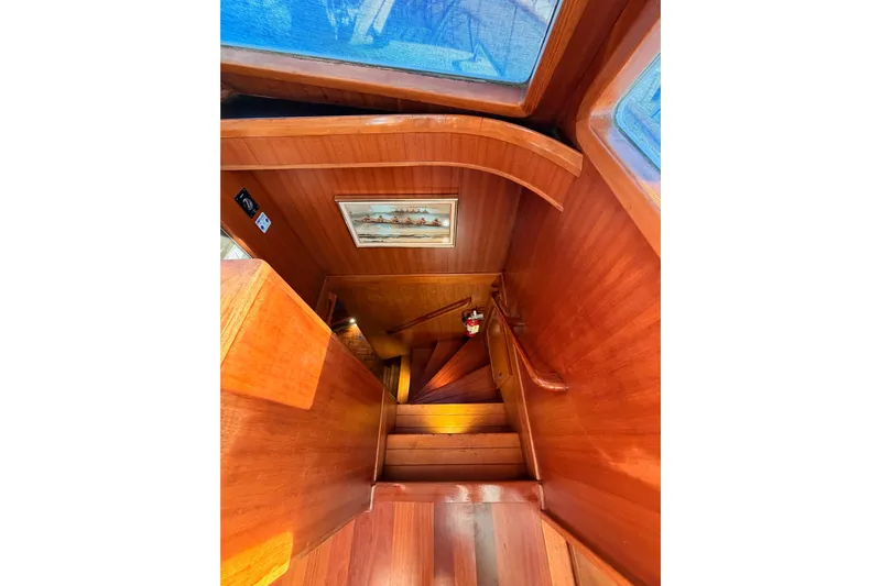 All The Way Yacht Photos Pics Wooden staircase inside 1984 Hartman-Palmer 60 Flush Deck Motor Yacht, featuring nautical decor.