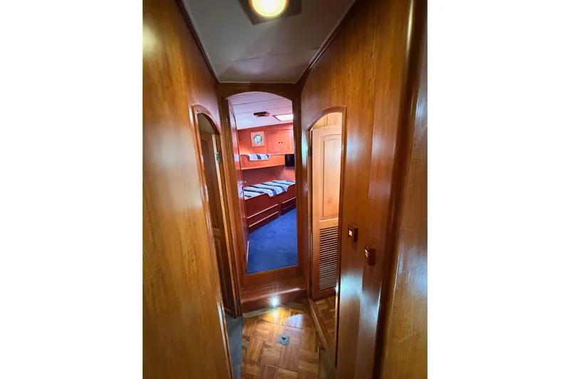All The Way Yacht Photos Pics 1984 Hartman-Palmer 60 Flush Deck Motor Yacht interior hallway with wood paneling and bedroom view.