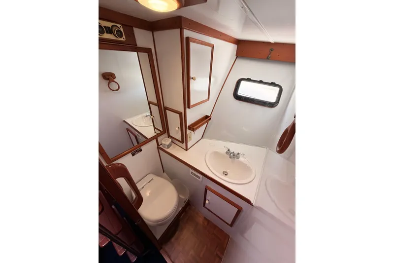 All The Way Yacht Photos Pics 1984 Hartman-Palmer 60 Flush Deck Motor Yacht bathroom with sink, toilet, and mirror.