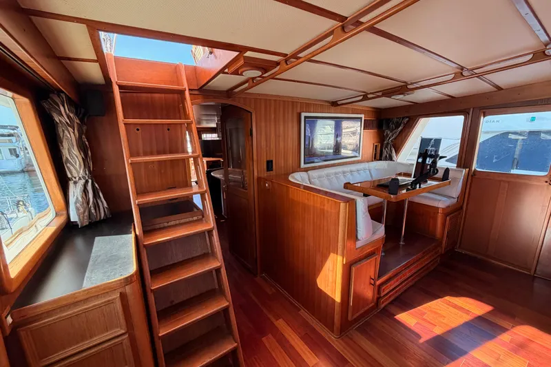 All The Way Yacht Photos Pics Interior of 1984 Hartman-Palmer 60 Flush Deck Motor Yacht with wood paneling and seating area.