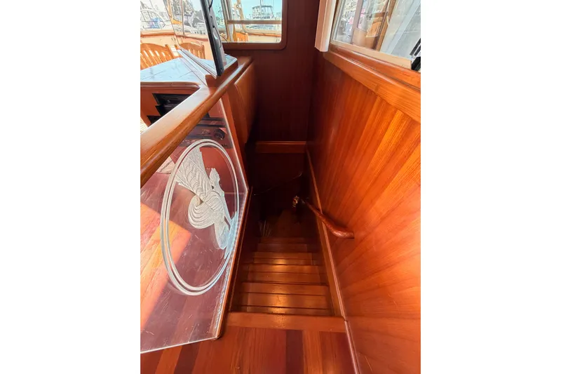 All The Way Yacht Photos Pics Wooden staircase on 1984 Hartman-Palmer 60 Flush Deck Motor Yacht, featuring etched glass panel.