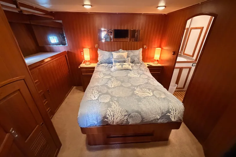 All The Way Yacht Photos Pics Luxurious bedroom in 1984 Hartman-Palmer 60 Flush Deck Motor Yacht, featuring elegant wood paneling.