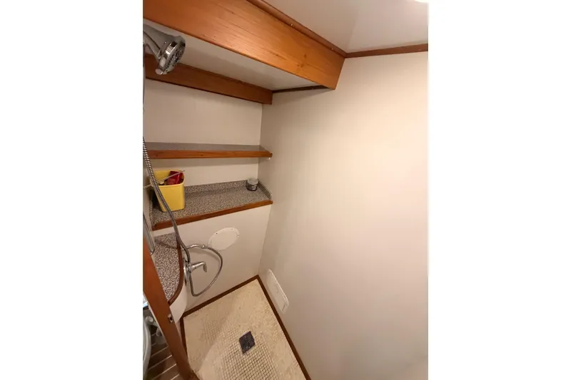 All The Way Yacht Photos Pics 1984 Hartman-Palmer yacht bathroom with shower, wooden shelves, and tiled floor.