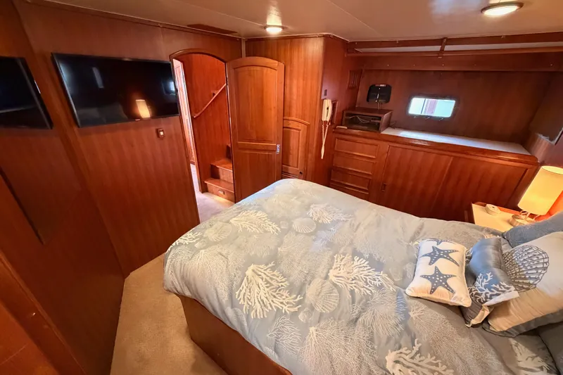 All The Way Yacht Photos Pics Luxurious 1984 Hartman-Palmer yacht bedroom with wood paneling and nautical-themed bedding.