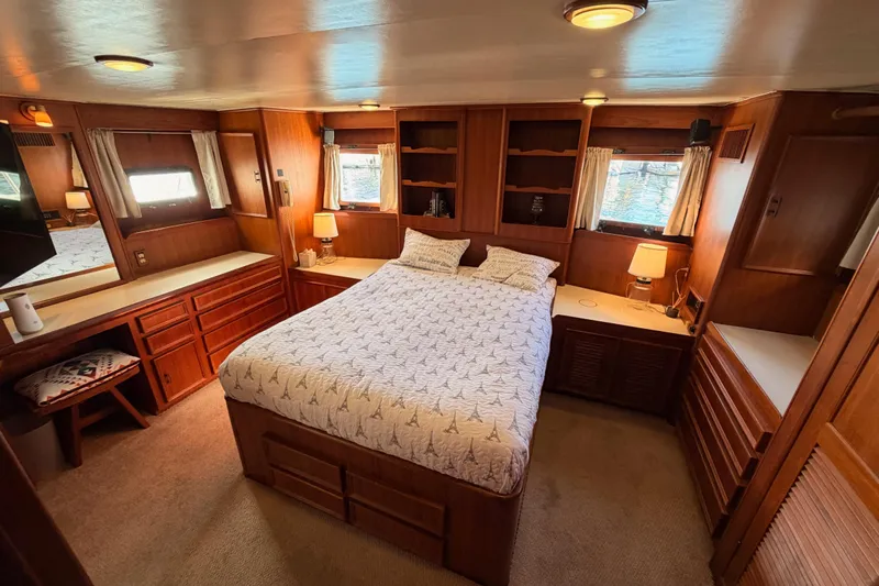 All The Way Yacht Photos Pics Luxurious 1984 Hartman-Palmer 60 Flush Deck Motor Yacht bedroom with wood paneling and cozy decor.