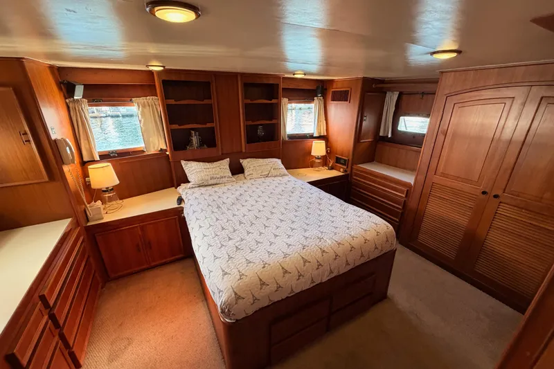 All The Way Yacht Photos Pics Luxurious 1984 Hartman-Palmer 60 Flush Deck Motor Yacht bedroom with wood paneling and cozy decor.