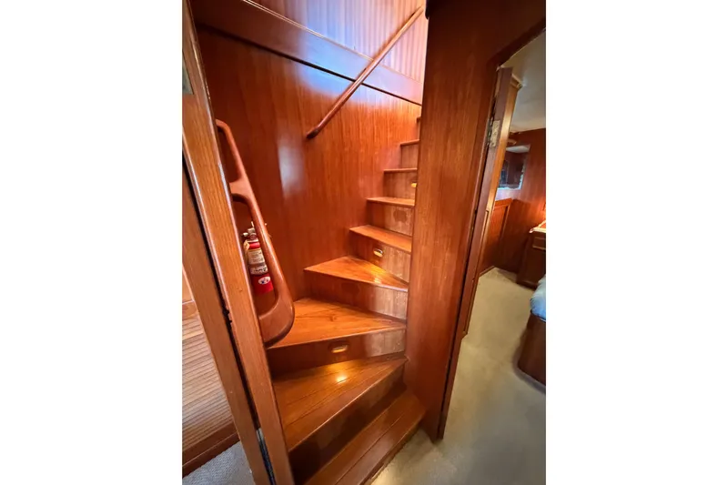 All The Way Yacht Photos Pics Wooden staircase inside 1984 Hartman-Palmer 60 Flush Deck Motor Yacht, featuring elegant design.