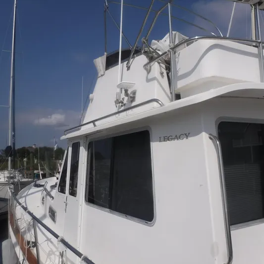 Ping Yacht Photos Pics 1998 Legacy 40' Flybridge yacht docked under clear skies.