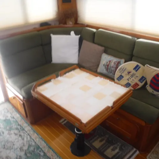 Ping Yacht Photos Pics Cozy interior of 1998 Legacy 40' Flybridge with green seating and wooden table.