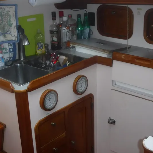 Ping Yacht Photos Pics 1998 Legacy 40' Flybridge yacht kitchen with sink, bottles, and wooden cabinets.