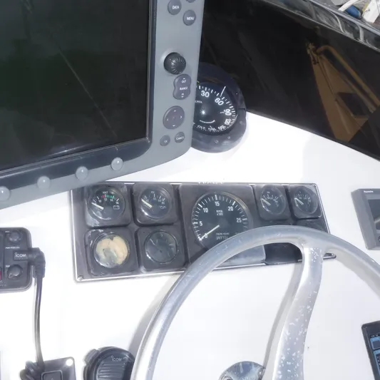 Ping Yacht Photos Pics Legacy 40' Flybridge 1998 helm with gauges, steering wheel, and navigation equipment.