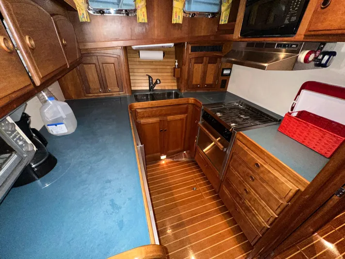  Yacht Photos Pics 2001 Sabre Sabreline 43 yacht kitchen with wooden cabinetry and modern appliances.