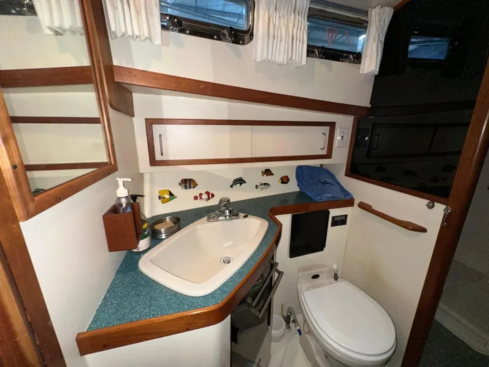  Yacht Photos Pics 2001 Sabre Sabreline 43 yacht bathroom with sink, toilet, and wooden accents.