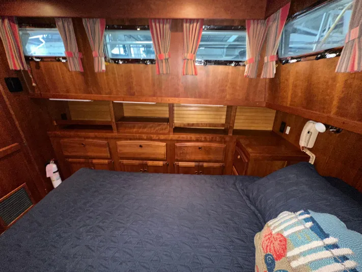  Yacht Photos Pics Cozy cabin interior of 2001 Sabreline 43 yacht with wood finish and blue bedding.