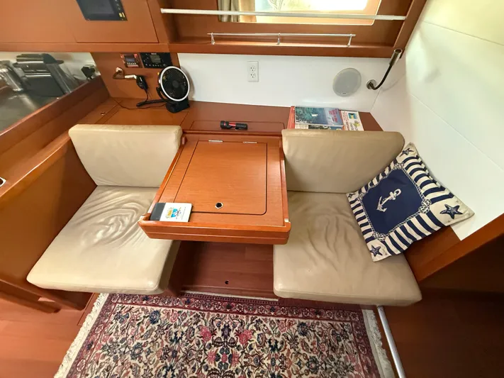 Wildflower III Yacht Photos Pics Cozy seating area on 2016 Beneteau Oceanis 45 yacht with nautical decor and wooden table.