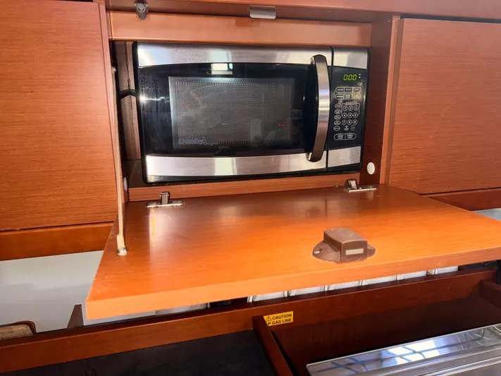 Wildflower III Yacht Photos Pics Microwave in 2016 Beneteau Oceanis 45 yacht kitchen, with wooden cabinetry.
