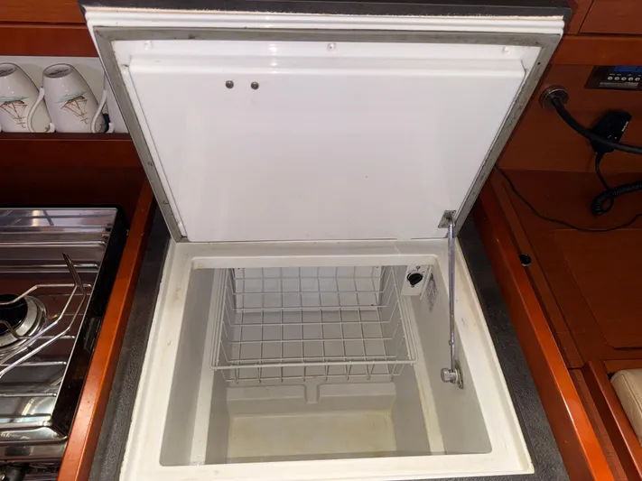 Wildflower III Yacht Photos Pics Open refrigerator in 2016 Beneteau Oceanis 45 yacht kitchen, with stove and cups nearby.