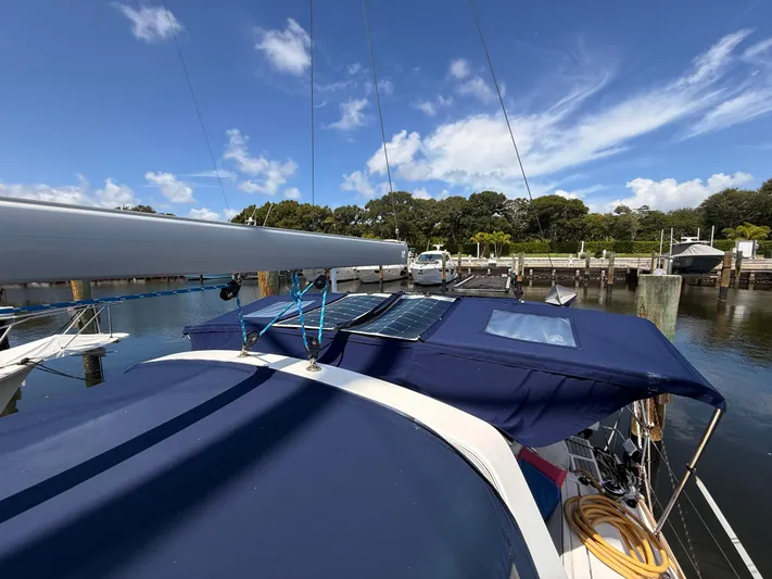 Wildflower III Yacht Photos Pics 2016 Beneteau Oceanis 45 sailboat docked, featuring solar panels and blue canopy under clear sky.