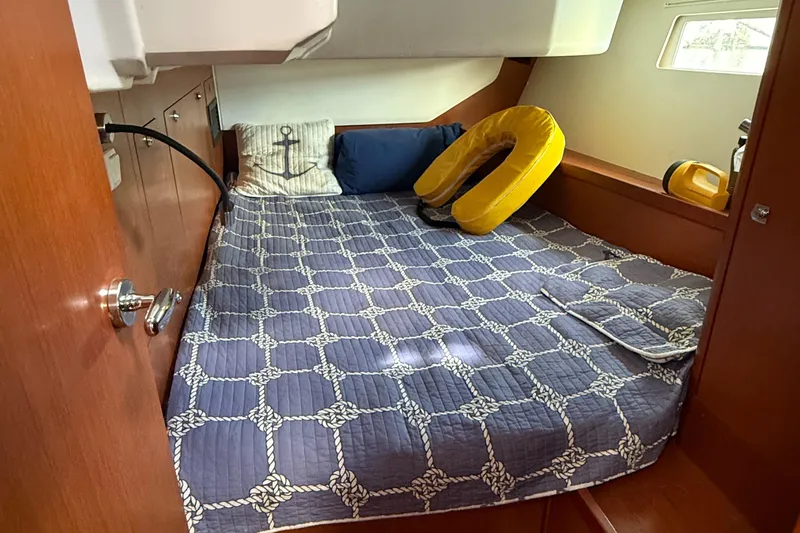 Wildflower III Yacht Photos Pics Cozy cabin interior of 2016 Beneteau Oceanis 45 with nautical-themed bedding.