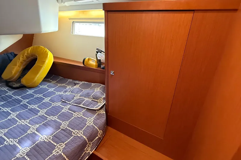 Wildflower III Yacht Photos Pics Cozy cabin interior of 2016 Beneteau Oceanis 45 with wooden cabinetry and patterned bedding.