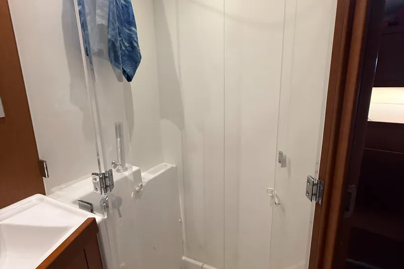Wildflower III Yacht Photos Pics Bathroom interior of 2016 Beneteau Oceanis 45 yacht, featuring a shower and wooden accents.