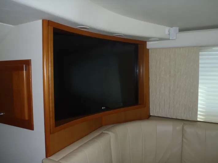 Great White Yacht Photos Pics Interior of 2001 Cabo Flybridge with mounted TV and leather seating.