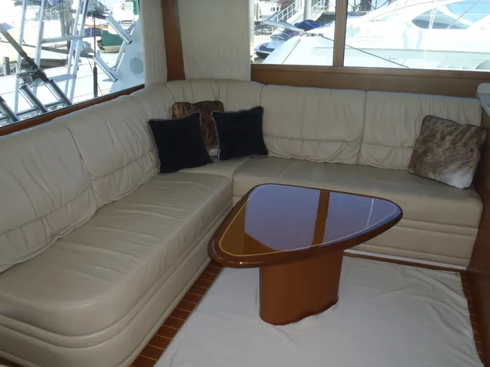 Great White Yacht Photos Pics Luxurious 2001 Cabo Flybridge yacht interior with cream leather seating and elegant wooden table.