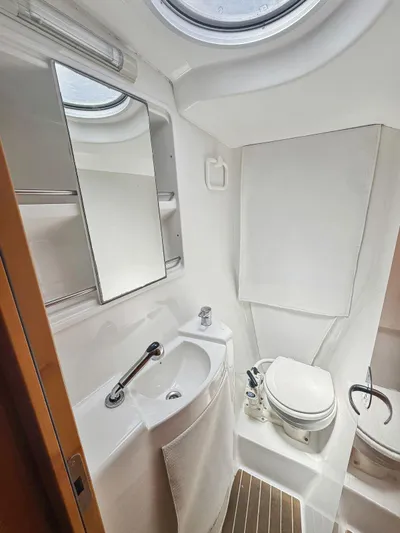 Knot Stupid Yacht Photos Pics Compact bathroom in 2005 Fountaine Pajot HIGHLAND yacht with sink, toilet, and mirror.