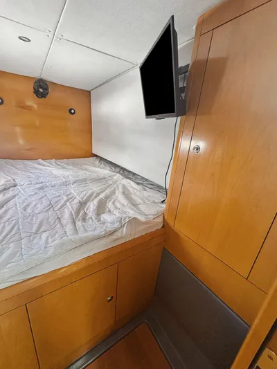 Knot Stupid Yacht Photos Pics 2005 Fountaine Pajot HIGHLAND cabin interior with bed, wooden cabinetry, and wall-mounted TV.