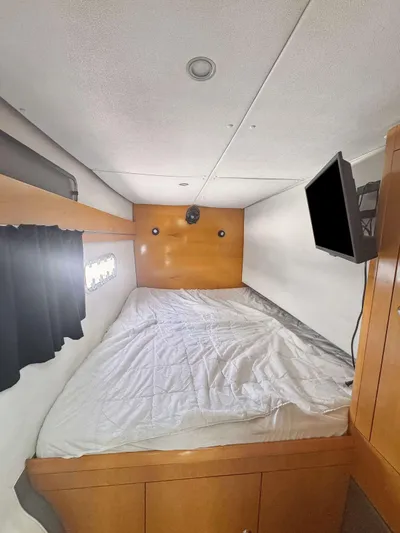 Knot Stupid Yacht Photos Pics 2005 Fountaine Pajot HIGHLAND cabin interior with bed and wall-mounted TV.