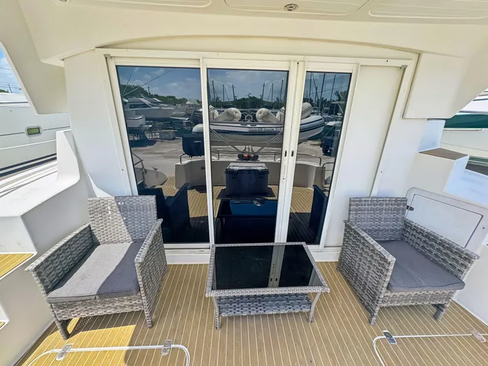 Knot Stupid Yacht Photos Pics Outdoor seating area on 2005 Fountaine Pajot HIGHLAND yacht with wicker chairs and glass table.