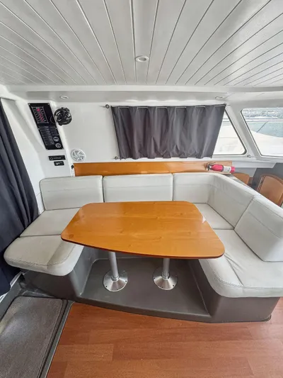 Knot Stupid Yacht Photos Pics 2005 Fountaine Pajot HIGHLAND interior with cozy seating and wooden table.