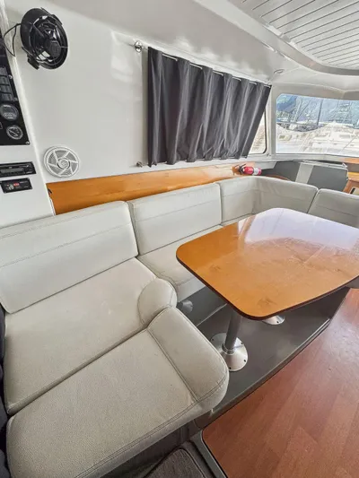 Knot Stupid Yacht Photos Pics Interior of 2005 Fountaine Pajot HIGHLAND yacht with cozy seating and wooden table.