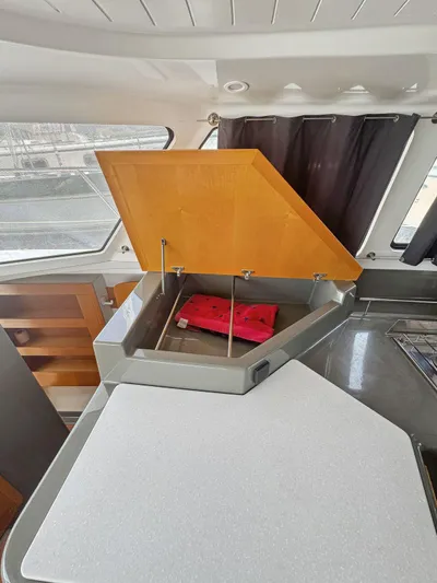 Knot Stupid Yacht Photos Pics 2005 Fountaine Pajot HIGHLAND interior with open storage compartment and red item inside.