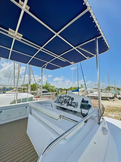 Knot Stupid Yacht Photos Pics 2005 Fountaine Pajot HIGHLAND boat helm with blue canopy, docked under clear sky.