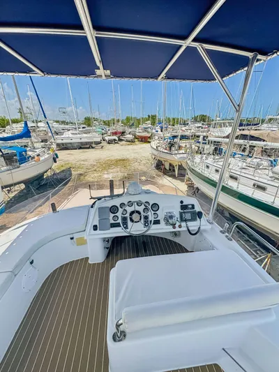 Knot Stupid Yacht Photos Pics 2005 Fountaine Pajot HIGHLAND yacht helm with marina view, under blue canopy.