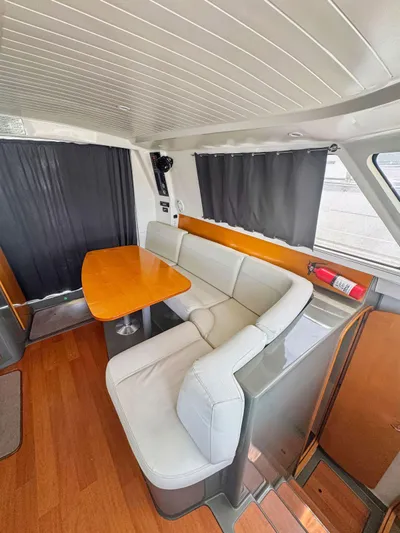 Knot Stupid Yacht Photos Pics Interior of 2005 Fountaine Pajot HIGHLAND yacht with modern seating and wooden table.