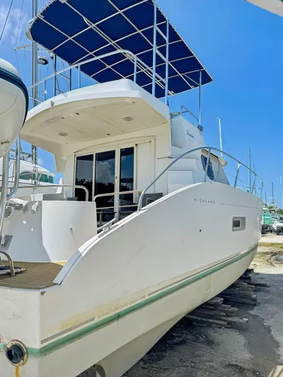 Knot Stupid Yacht Photos Pics 2005 Fountaine Pajot HIGHLAND yacht with blue canopy, docked under clear sky.